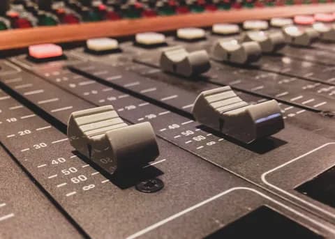 Close-up of studio mixing console faders and dials