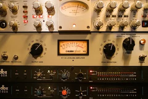 Close-up of a studio compressor knob and faceplate with soft lighting