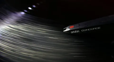Close up macro shot of dust sitting in the groove of a vinyl record